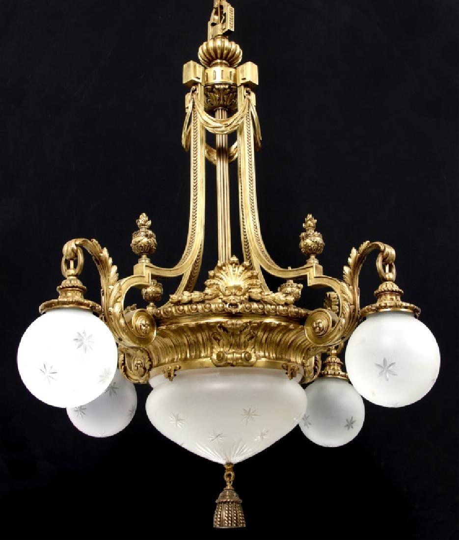 Cast Bronze Chandelier with Cut Glass Shades: Cast Bronze Chandelier with Cut Glass Shades. Bronze hanging fixture has 4 scrolling support arms with flame and urn finials, 4 filigree decorated arms with pendant sockets and lower support ring havi