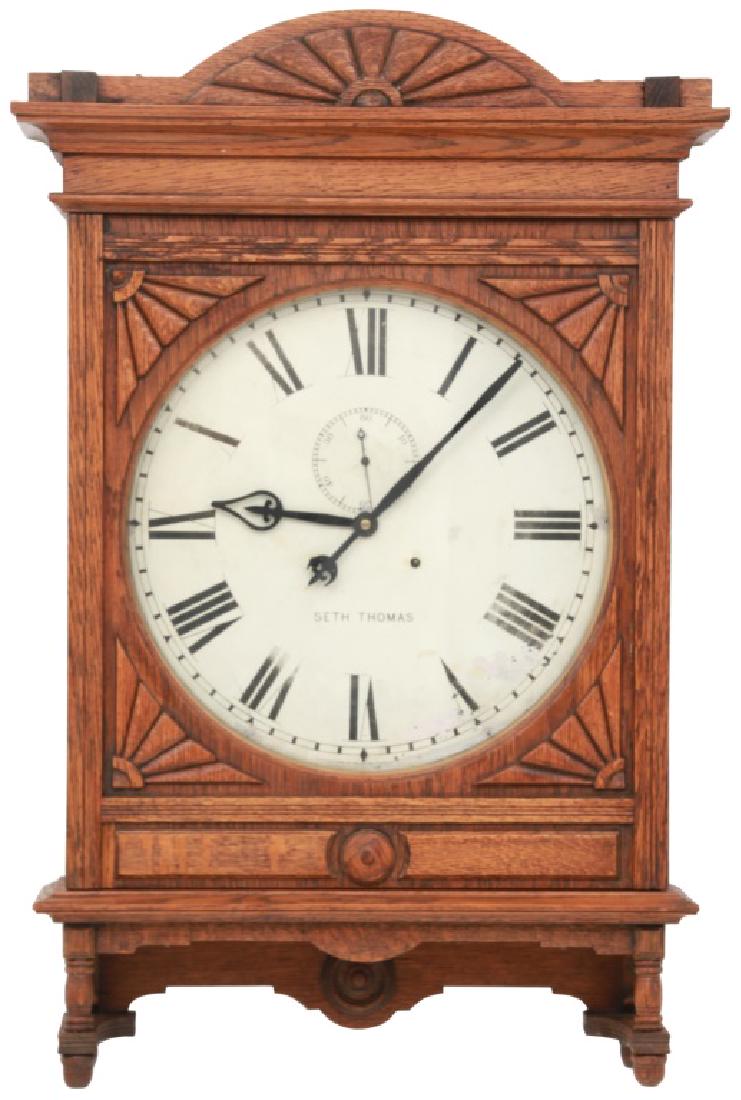 Oak Seth Thomas 18 Inch Lobby Clock: Oak Seth Thomas 18 Inch Lobby Clock. Original 18" painted metal dial signed "Seth Thomas" has black Roman hour numbers, fancy black painted pierced spade hour hand and pointer minute hand with counter