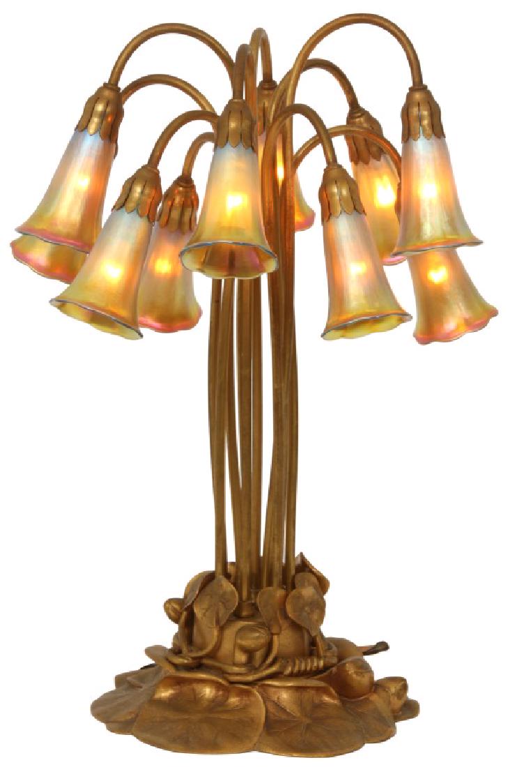 Tiffany Studios Dore Bronze 10 Light Lily Lamp: Tiffany Studios Dore Bronze 10 Light Lily Lamp. The dore bronze pond lily pad base with floral buds, has 10 long tubular stems that curl over at the top with porcelain sockets and leafy fitters at the