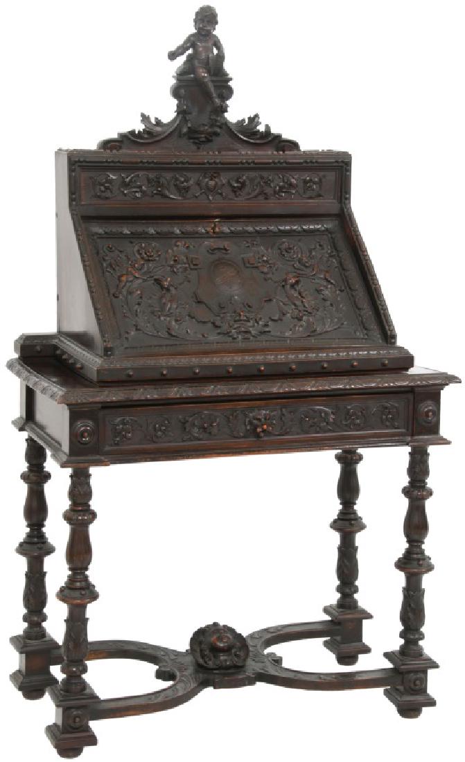 Carved Walnut Slant Front Desk with Cherub: Carved Walnut Slant Front Desk with Cherub. Heavily carved walnut continental desk having a 3 dimensional cherub on the crest, a top drawer with carvings of filigree with flowers, griffin heads facing