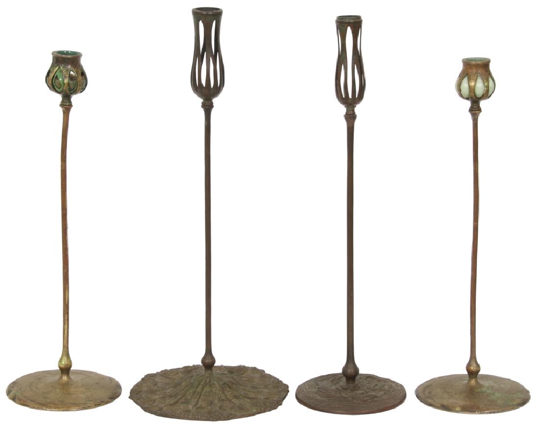 Four Tiffany Studios Candlesticks (as is): Four Tiffany Studios Candlesticks. 1.) A pair with blown out glass inserts having damage to one glass insert, number S 157. 17.5 in. high x 5.75 in. diameter. 2.) Tall candlestick with blown out glass
