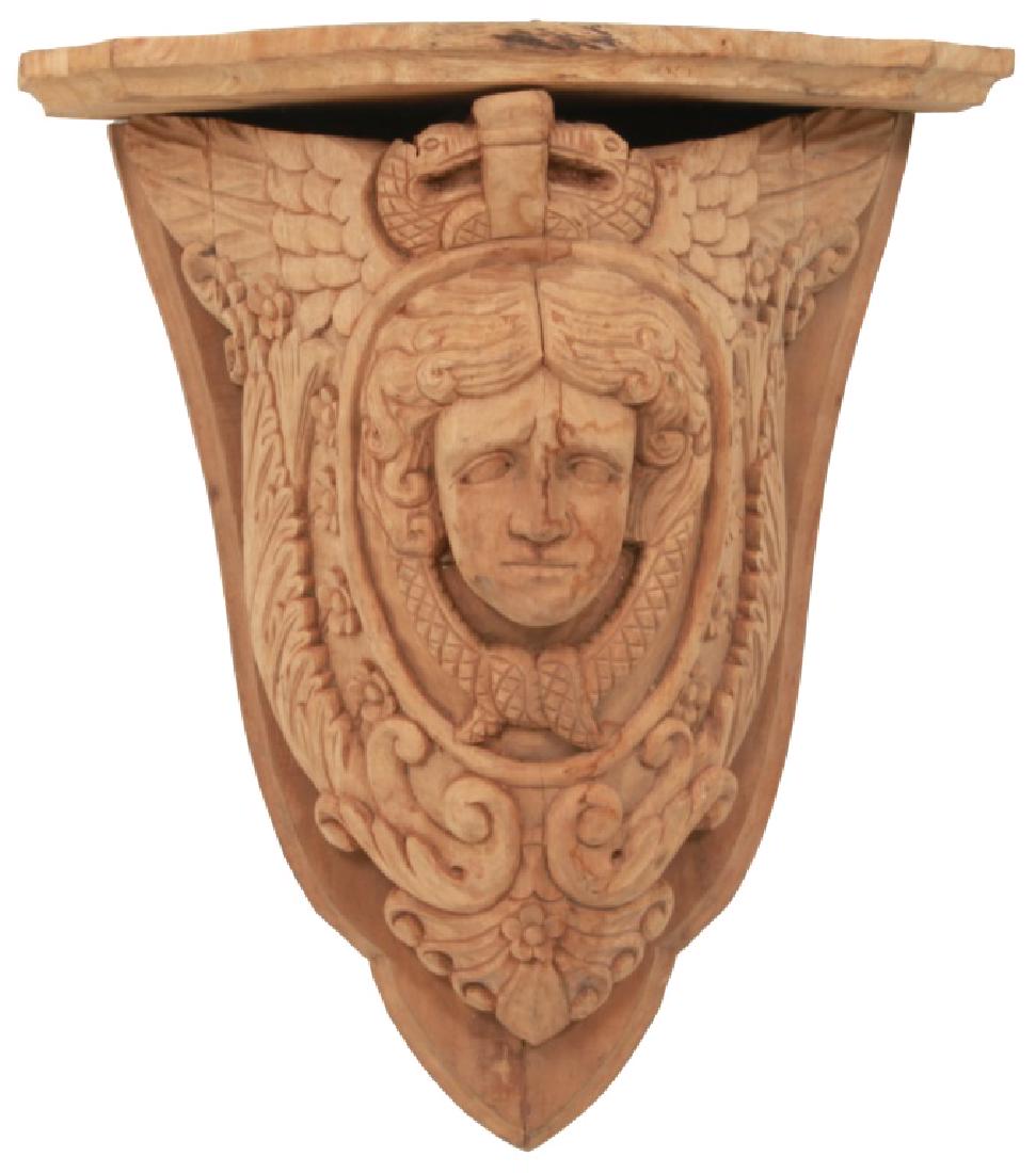 Pair of Carved Mahogany Figural Shelves: Pair of Carved Mahogany Figural Shelves. Pair of figural carved mahogany corbeled shelves with maiden head medallion centers and winged serpents above, unfinished. Dimensions: 17 in. wide x 18 in. hig