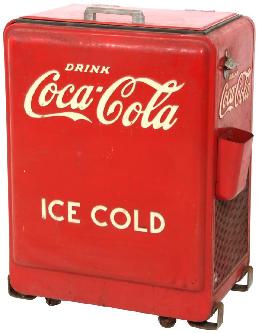 Coca-Cola Cooler: Coca-Cola Cooler. This freestanding cooler has a bottle opener with catch tray on the side and is in original condition, showing typical paint wear. The label underneath is marked "The Coca-Cola Compa
