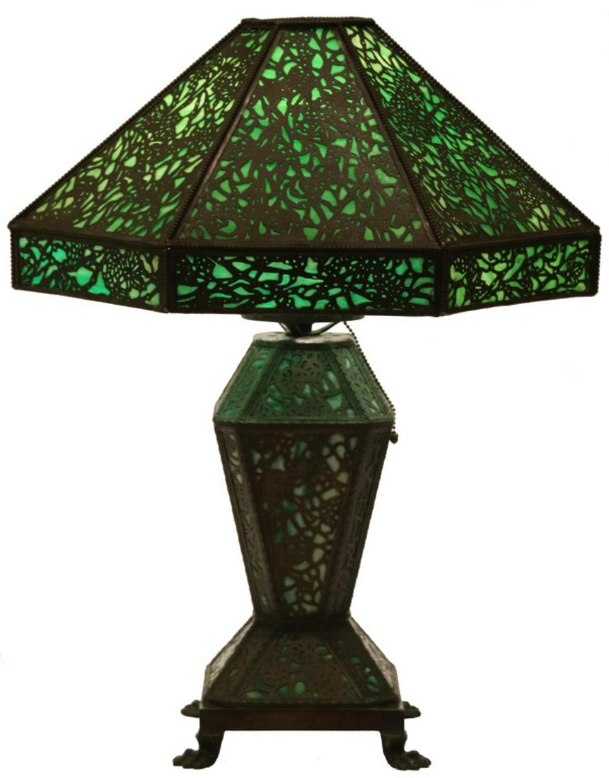 Riviere Studios Overlay Table Lamp: Riviere Studios Overlay Table Lamp. The 20 in. diameter hexagonal shade has panels of green and white glass which are overlaid and pierced decorated in bronze with a grape leaf and vine pattern having