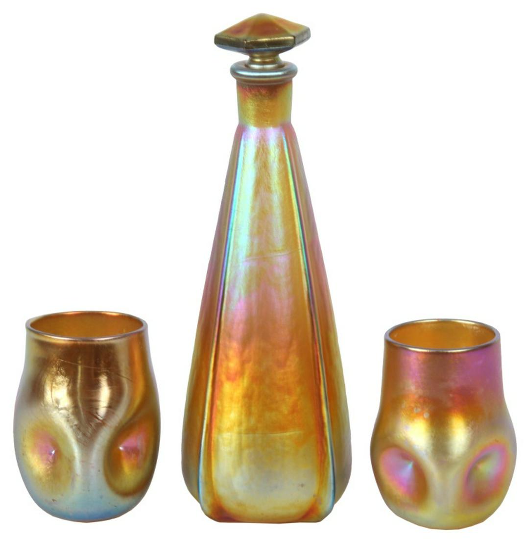 Lot of Quezal Art Glass: Lot of Quezal Art Glass. Quezal "Melba" perfume bottle has a cone-shaped body, multi-color iridescence, four vertical ribs and a hexagonal stopper; signed on the underside, "Melba/Q." Two chips on the