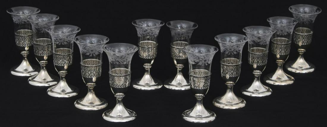 12 Tiffany & Co. Sterling Silver Cups: 12 Tiffany & Co. Sterling Silver Cups. Glass and sterling silver cups have a pierced design with floral and leaf etched glass inserts that are in a trumpeted form; signed on the underside, "Tiffany & 