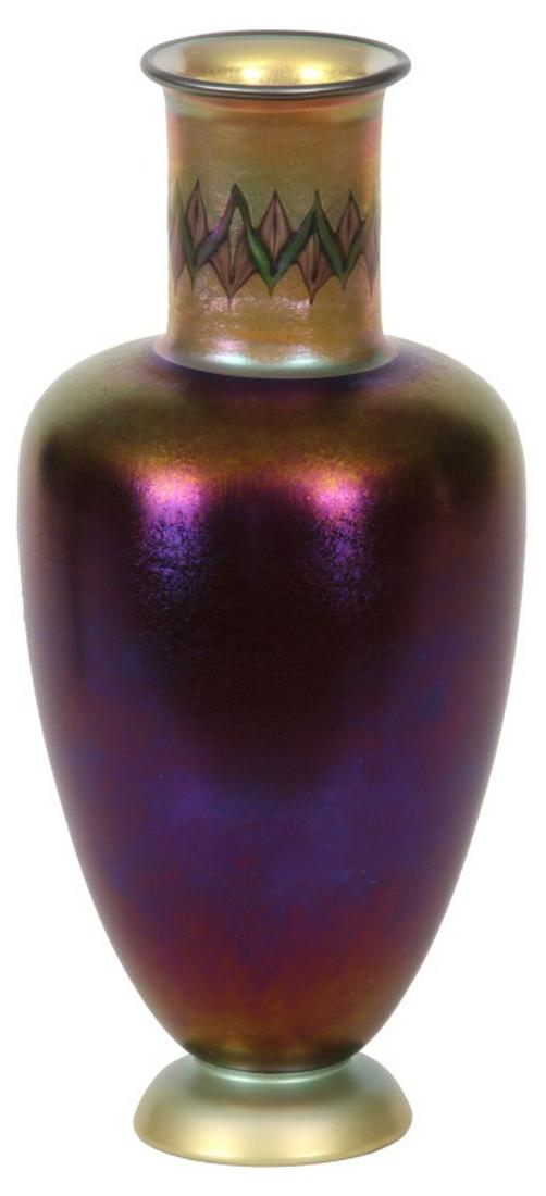 Tiffany Studios Tel El Amarna Vase: Tiffany Studios Tel El Amarna Vase. The Tiffany vase in a classic form with deep shoulder and flared rim has a purple iridescent body and gold iridescent neck, decorated in green and pale pink; signed