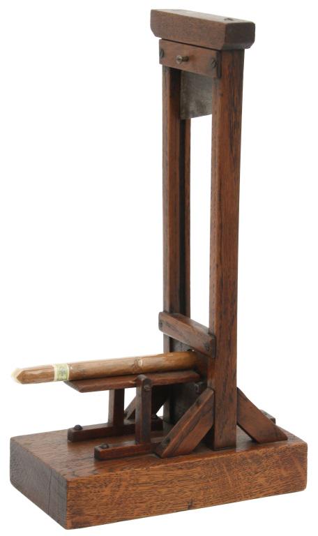 Oak Guillotine Model Cigar Cutter: Oak Guillotine Model Cigar Cutter. Oak frame takes the form of a medieval guillotine with sharp fixed lower blade and upper blade sliding within the framework. Good original finish & condition. 12.75 