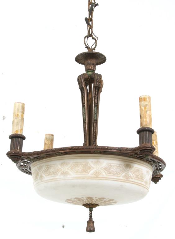 Bronze Art Deco Chandelier: Bronze Art Deco Chandelier. The bronze frame supports an acid etched shade with tassel below and 4 faux candle sockets above. Dimensions: fixture - 27 in. high x 23.75 in. diameter; shade - 6 in. high