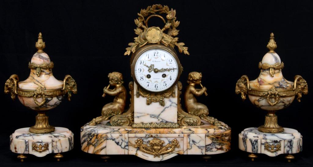 French Gilt Bronze & Marble Garniture Set: French Gilt Bronze & Marble Garniture Set. Figural bronze case with Pan playing flutes, the urns with ram head handles. The eight day brass movement is running and striking, has a half an hour strike