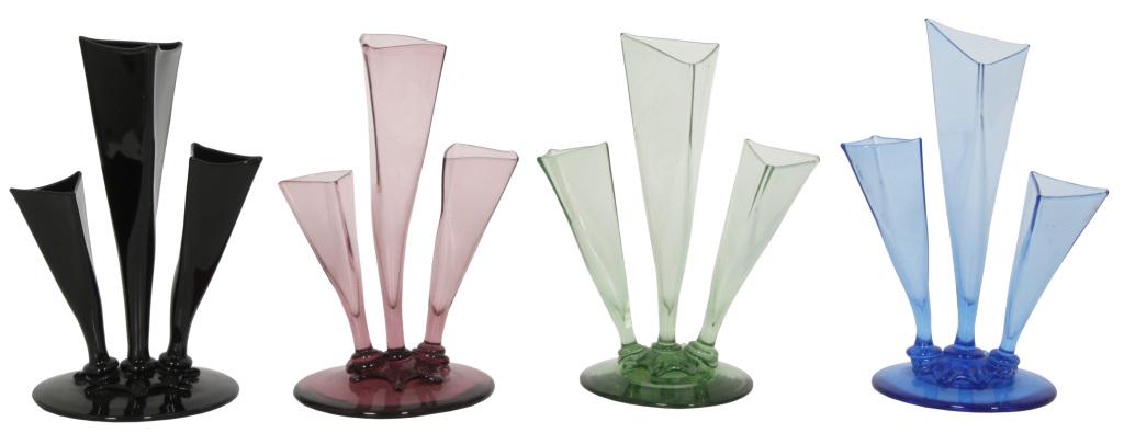 Four Steuben Three-Stemmed Epergnes: Steuben epergnes have three applied triangular tapered glass flutes of various sizes attached to round platform bases and range in color from black, purple, green and blue. Dimensions: 10 in. high x 7