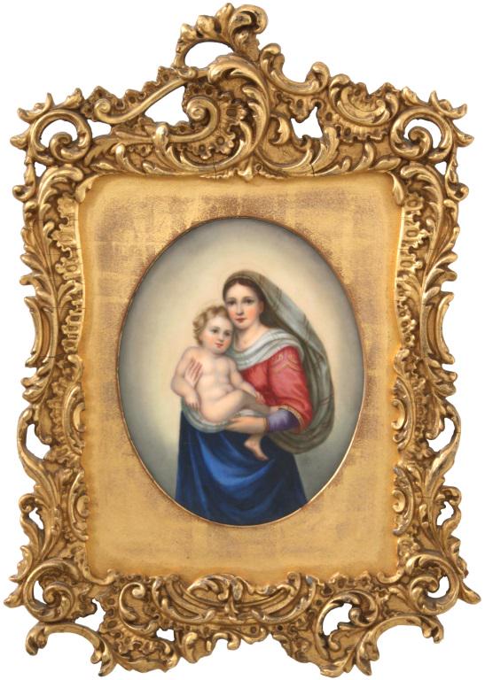 Madonna & Child Porcelain Plaque after Raphael: The hand painted oval porcelain plaque depicts Madonna holding the baby Jesus; she wears a silk sash and has a striped headdress. The plaque is mounted in a gilt decorated frame with filigree. Dimensi