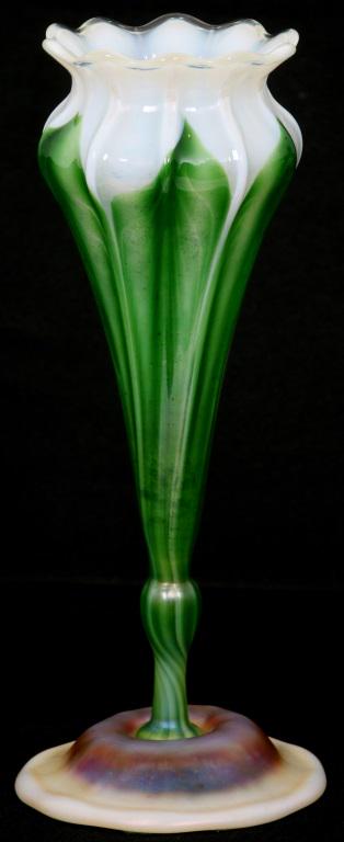 Tiffany Studios Favrile Glass Floriform Vase: Tiffany Studios Favrile glass floriform vase has a bulbous foot applied to a green and white stem that transitions to a pulled feather design; has a ruffled rim and ribbed body. Signed on the undersid