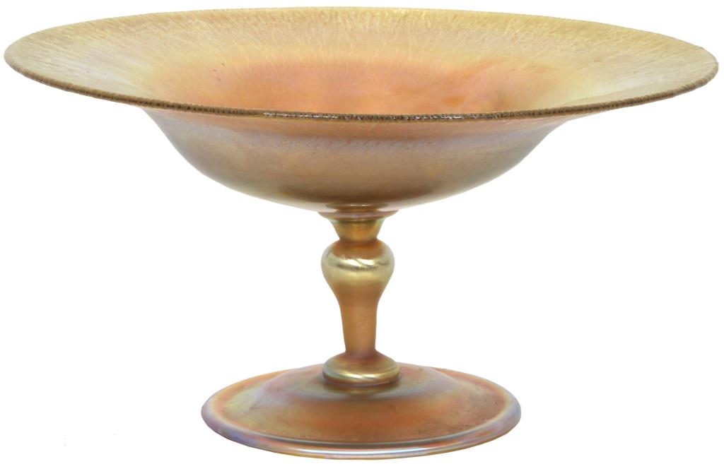 Tiffany Studios Favrile Glass Compote: Gold iridescent Favrile Glass compote has an 11.5 in. diameter bowl with crackled edge; rests on a round base which supports the stem having a knob center. Signed on the underside, "L. C. Tiffany - In