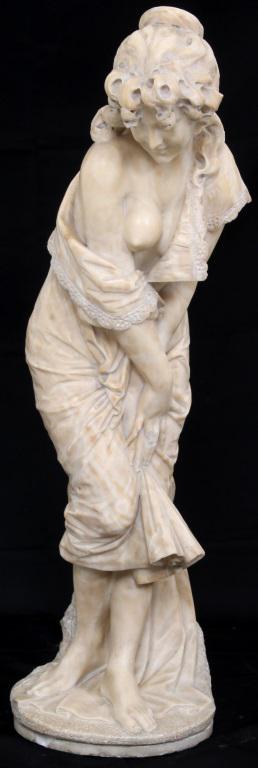 Alabaster Sculpture of a Nude Woman: The alabaster sculpture depicts a nude woman wearing draping garments and slightly bending over with her hands crossed. Some damage to the back lower portion. Dimensions: 35 in. high x 14 in. wide x 9