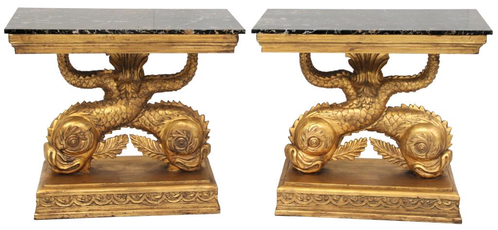 Pair of Gilded Marble Top Dolphin Tables: Pair of matching gold gilded marble top console tables having large dolphins with their tails crossing at the center and meeting at a central cartouche supporting the black & white striated marble top