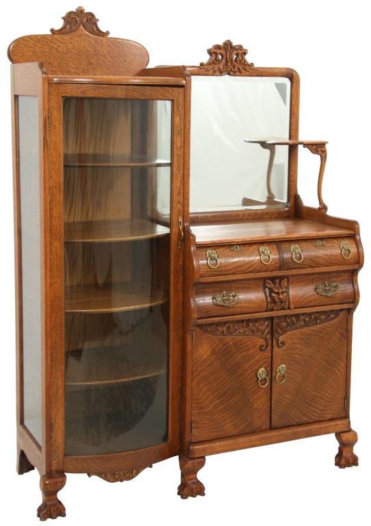Oak Side by Side China Buffet: The china buffet has a right side with a shaped beveled mirror below two open mouth lion heads and a small shelf support; below are two drawers above one large drawer with a central mythical creature 