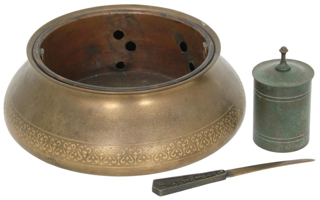 Three Tiffany Studios Items: Three Tiffany Studios items include a bronze fernery with a decorated border, cigarette dispenser and a letter opener. 1) Signed "Tiffany Studios, New York, 1701"; 4 in. high x 10.75 in. diameter. 2) 