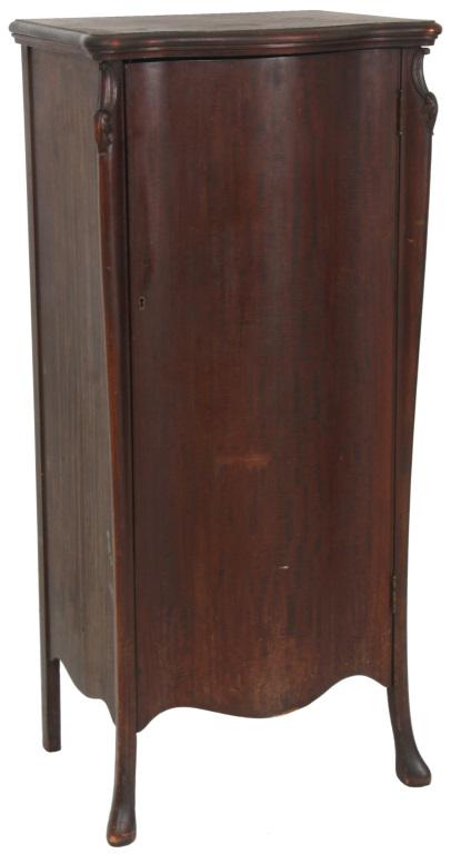 Herzog Mahogany Serpentine Front Music Cabinet: Serpentine front music cabinet has a long serpentine front door, carved highlights on the corners and 12 sheet music shelves in the interior. Original finish, signed inside with a decal for "Herzog Ar