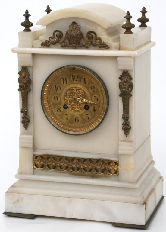 French Eight Day Alabaster & Bronze Mantle Clock: French mantle clock has a pure white onyx case with gilded bronze mounts. Eight day time & strike French brass movement. Dimensions: 14 in. high x 10 in. wide x 6.5 in. deep. Weight: 35.15 lbs.