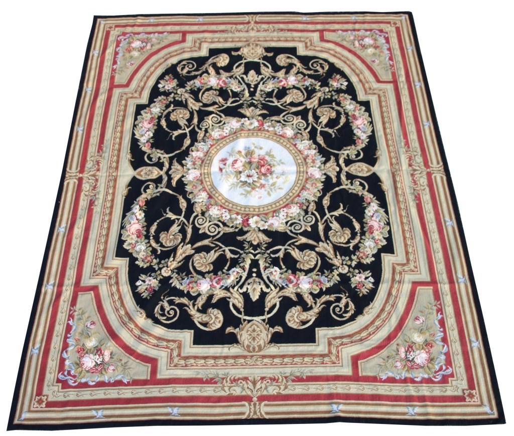 Handmade Aubusson Rug: Abusson rug has a dark blue center panel with filigree, wreath and strands of garland with roses, flowers and leaves; has intricate borders with floral clusters at the corners. Overall, very nice cond