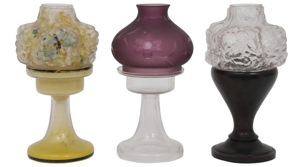 Three Pairpoint Candle Lamps: Lot of three Pairpoint candle lamps with colored glass bases, 2 with puffy shades, early 20th century. 8 in. high x 4 in. diameter