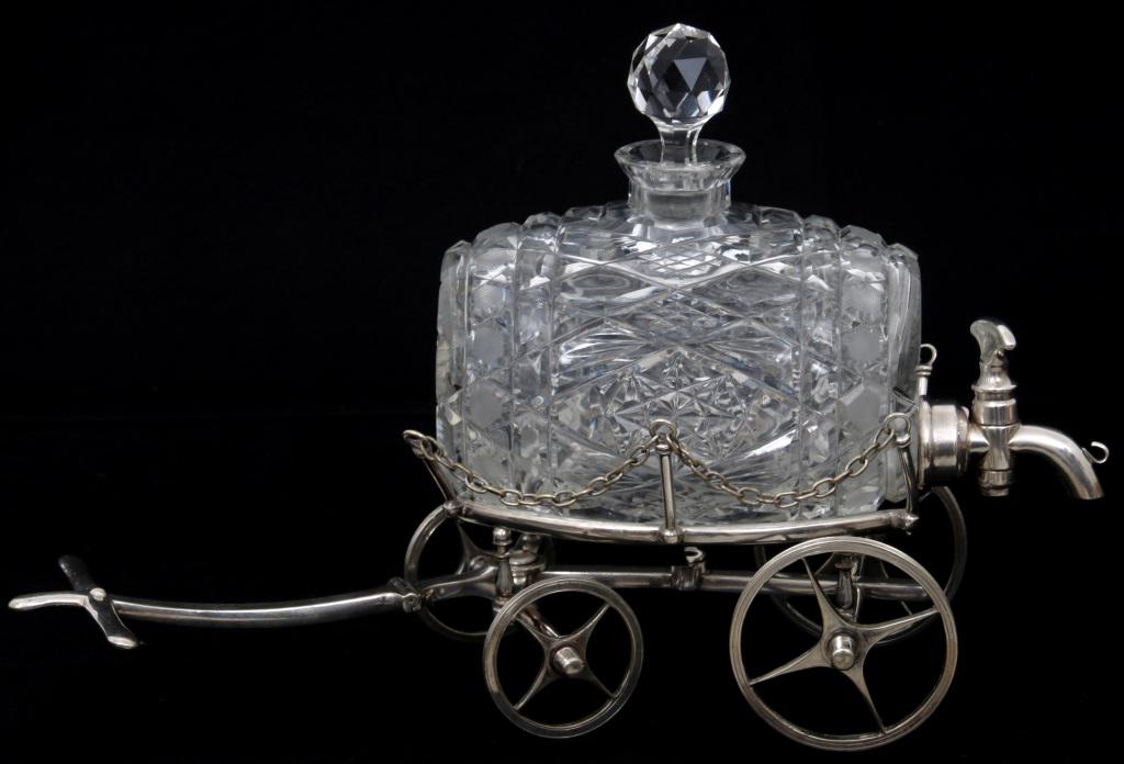 Brilliant Cut Glass Barrel Decanter on Wagon: Cut glass barrel decanter with diamond cut decoration has a faceted glass ball stopper and is supported by a silver plated wagon. Very good condition with no damage or repair. 10 1/2 in. high x 16 in.