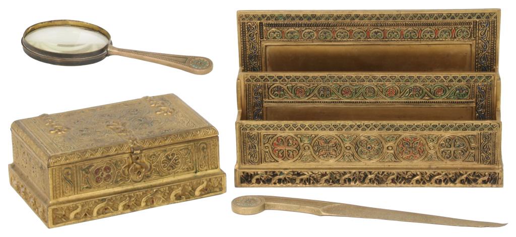 Four Tiffany Studios Dore Bronze Desk Pieces: 1) Venetian pattern box with hinged lid is signed "Tiffany Studios, New York, 1680"; 2 1/4 in. high x 5 1/2 in. wide x 3 3/4 in. deep. 2) Venetian pattern letter holder has red and green highlights an