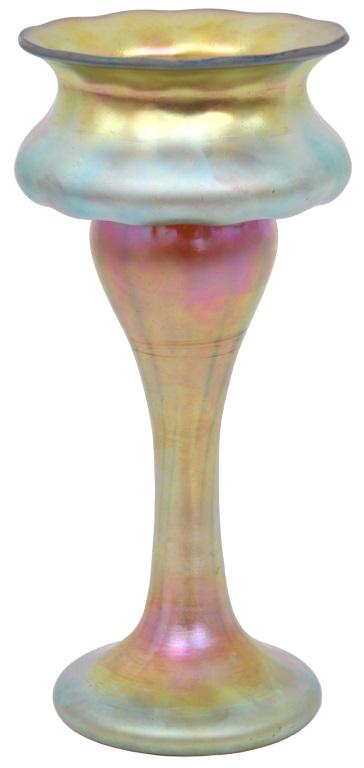 Steuben Gold Aurene Vase: Steuben gold Aurene art glass vase has a raised foot with tapering stem that leads to an unusual shaped bowl; it is finished off with a flared and scalloped rim. Signed on the underside, "Aurene 243."