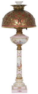 Victorian Banquet Lamp: Victorian banquet lamp with brass covered glass shade supported by a porcelain base decorated with scenes of classical figures. 31.5 in. high x 12.5 in. diameter.