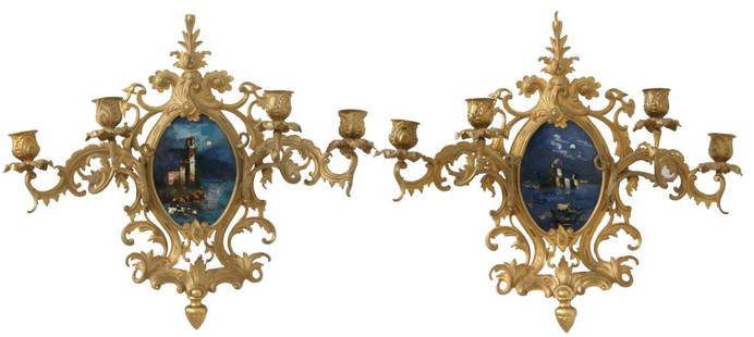 Pair of Rococo Style Gilt Bronze Wall Sconces: Pair of Rococo style gilt bronze wall sconces with an oval moonlit landscape scene surrounded by scrolling decoration and four candle arms. 16 in. high x 18.5 in. wide.