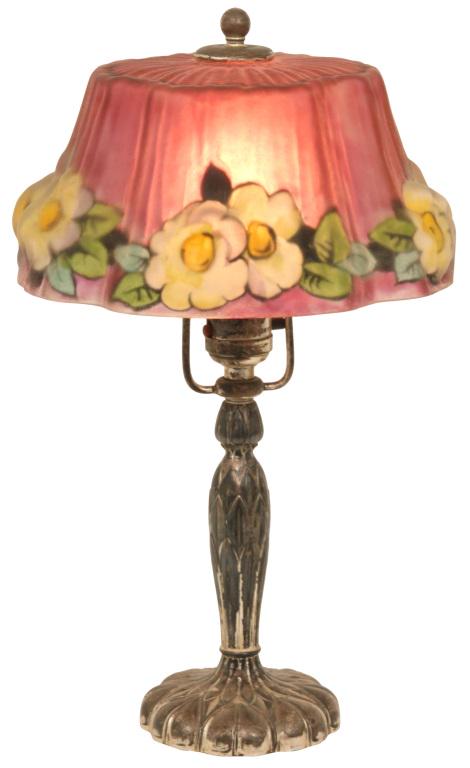 Pairpoint Puffy Boudoir Lamp: Pairpoint puffy boudoir lamp has a Stratford shade decorated with dogwood flowers set against a cranberry background. Supporting the shade is a silvered base with palm leaf motifs; signed on the under