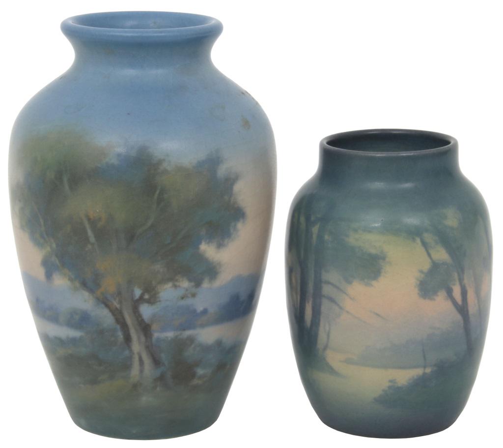 Two Rookwood Pottery Vellum Vases: 1) Rookwood Vellum cabinet vase has a landscape scene with numerous trees and mountains in the distance; marked on the underside with flame mark dating it to 1922, shape number 645E, V for Vellum, and