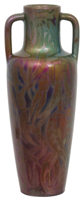 Clement Massier Handled Vase: Clement Massier vase with handles is in a baluster form and decorated with foliate throughout. Signed on the underside, "M.C.M. Golfe-Juan AM." Very good condition with no damage or repair. 14 5/8 in.