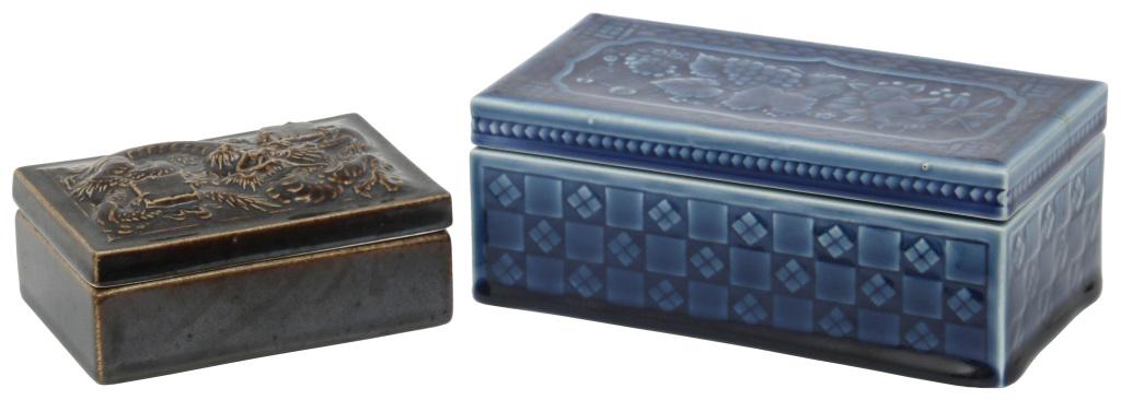 Two Rookwood Pottery Boxes: 1) Rookwood box has a dragon motif on the cover and is finished in a deep brown glaze; marked on the underside with flame mark dating it to 1957, has shape number 7079 and is signed "Rookwood, Cincinn