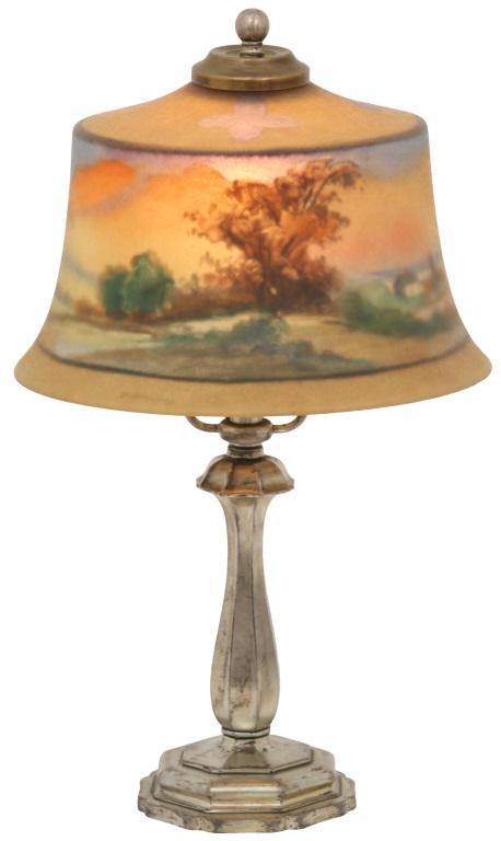 Pairpoint Exeter Boudoir Lamp: Pairpoint boudoir lamp has an Exeter shade with a reverse painted landscape scene, signed "The Pairpoint Corp'n." Supporting the shade is a gilt metal base with an octagonal platform. 14 in. high x 8 