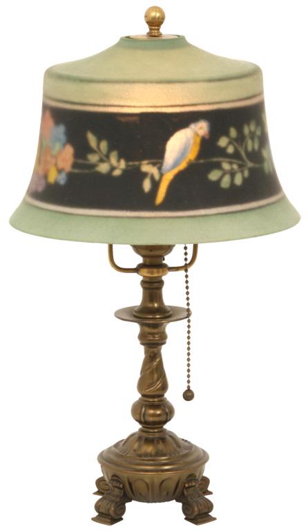 Pairpoint Exeter Boudoir Lamp: Pairpoint boudoir lamp has an Exeter shade with reverse painted parrots and floral decoration, supported by a gilt metal base signed "Pairpoint" and numbered "D3065"; missing cap. 15 in. high x 8 1/2 