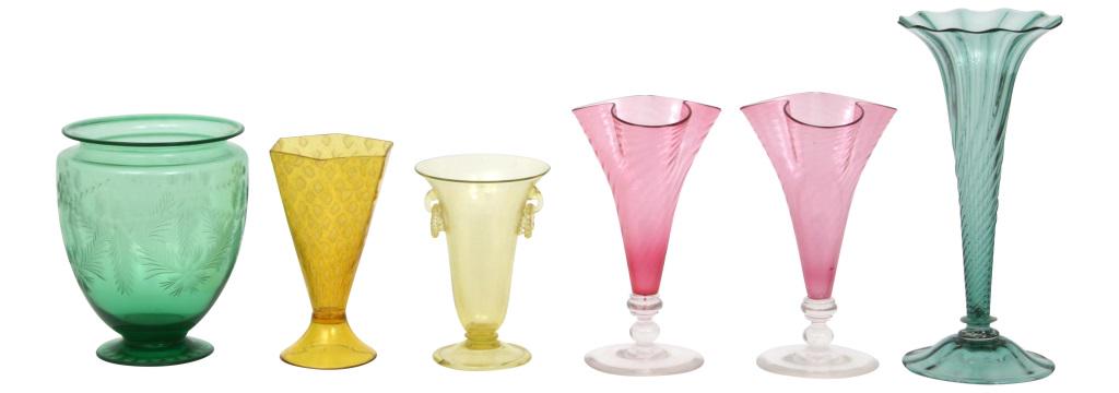 Six Steuben Vases: Lot of six Steuben vases in trumpeted, faceted and bulbous forms having swirled and etched designs with one vase having glass ring handles. The faceted yellow and one of the pink vases are signed "Ste
