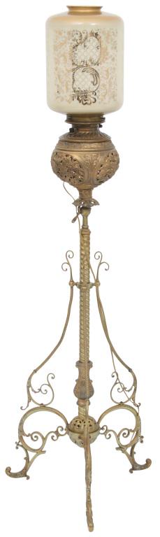 Victorian Brass Piano Lamp: Victorian adjustable brass piano lamp with a pearl glass shade having gilt decoration and spiral center post leading to scrolled legs. 56 in. high x 18 in. diameter (base), 12 in. high x 8 1/2 in. dia