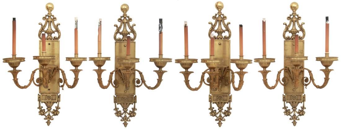 Set of 4 Matching Bronze 3 Light Wall Sconces: Set of 4 Matching Bronze 3 Light Wall Sconces. Each has a long rectangular back plate with pierced and relief decorated pendant crest; has 3 scrolling filigree arms branching up with electric candle l