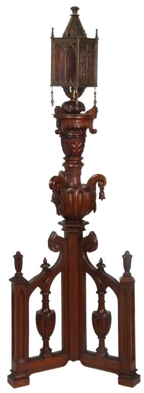 Carved Walnut Gothic Style Torchiere Lamp: Gothic Style Torchiere Lamp has a 3 legged base with pierced carved gothic arches, turned center posts and finials at the ends, 3 handled floriform urn with hanging bell flowers in the center of the s