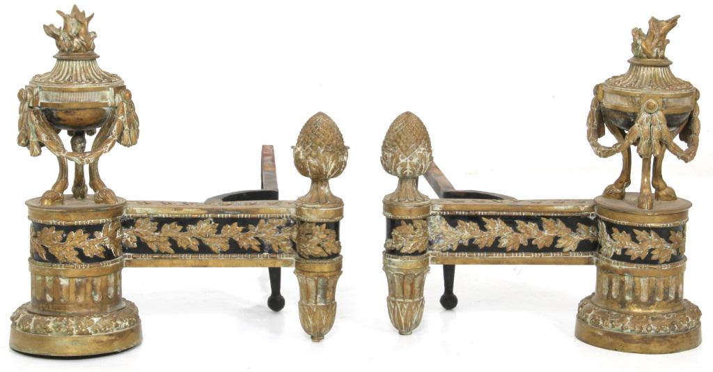 Pair of French Bronze Chenets: Pair of French bronze chenets with pineapple finials, foliate bands and urns decorated with flame finials, garland and three hoofed feet. 17 in. high x 16 in. wide x 26 in. deep.