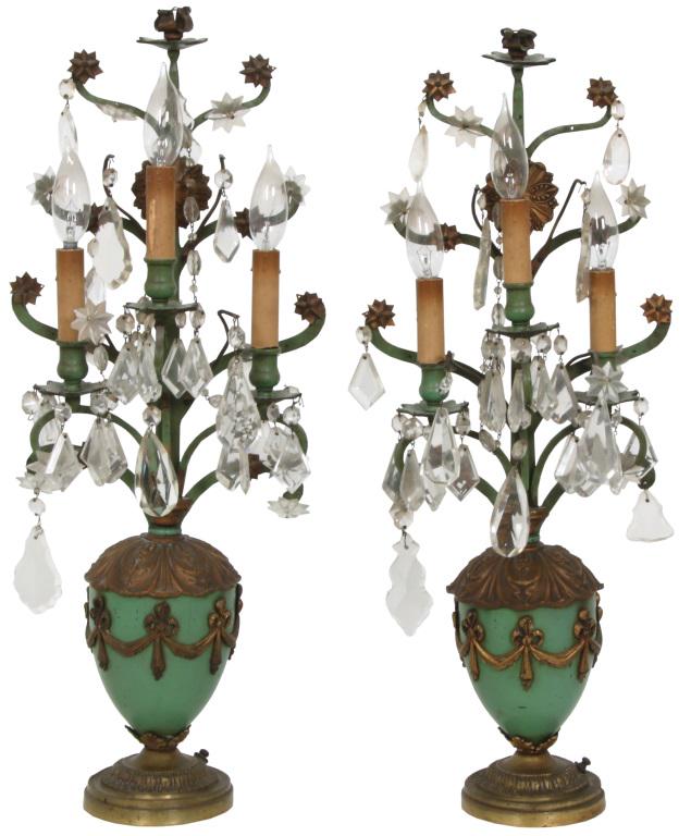 Pair of French Candelabra Lamps: Pair of French candelabra lamps with hanging cut glass prisms, star motifs, two electrified candle arms and urn shaped bodies with acanthus and wreath decoration. 26 in. high x 10 in. wide x 5 in. dee