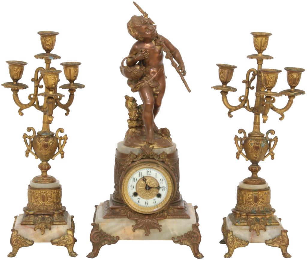 Waterbury Three-Piece Clock Garniture: Waterbury three-piece clock garniture with clock having onyx and metal trim adorned at the top with a figure of a child with a basket and staff, matching pair of Waterbury candelabras, 8-day brass mov