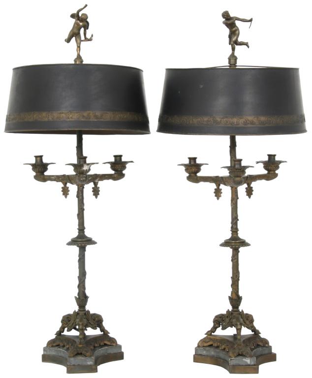Pair of Figural Bronze Lamps: Pair of Figural Bronze Lamps, late 19th century, with cherub and putti finials, three arms with foliate ornamentation, twisted vine stem, figural legs with hoofed feet 36 x 16 inches