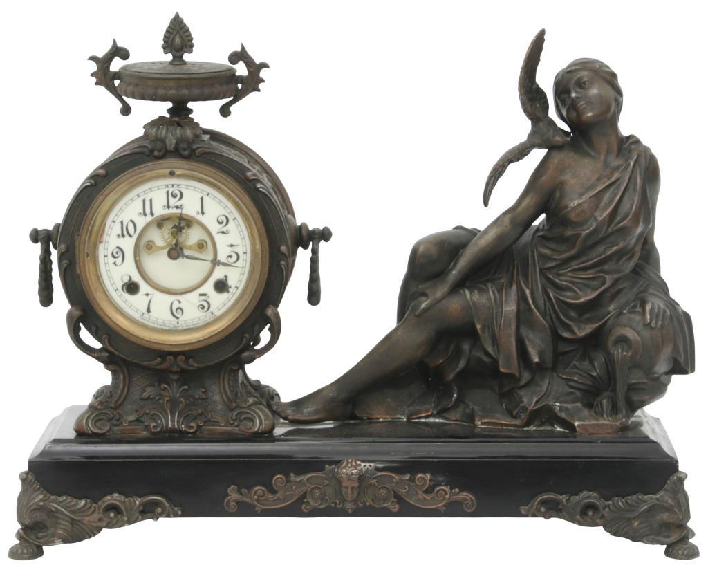 New Haven "La Caresse" Figural Mantel Clock: New Haven "La Caresse" Figural Mantel Clock, New Haven, Connecticut, circa 1900, patinated metal figure of a woman and bird on a painted iron base with serpentine feet, 4 1/2-inch porcelain dial, 8-da