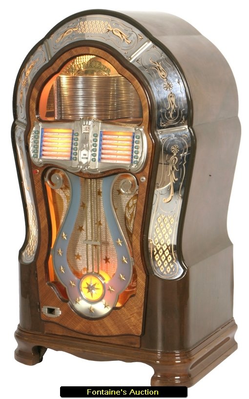 Wurlitzer Multi-Selector Phonograph Juke Box Model 1: Wurlitzer Multi-Selector Phonograph Juke Box Model 1080. A stylish walnut case with classic curves, the door front has mirrored borders with gold design within. The face of the door has 24 selector bu