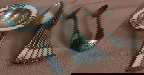 8 Pc Enameled Sterling Tea Spoons.: 8 Pc Enameled Sterling Tea Spoons .925 Silver. Set has a nouveau floral pattern in blue, green and white with a worn gold wash; includes a tea strainer, sugar tongs and 6 spoons w/ unidentified orient