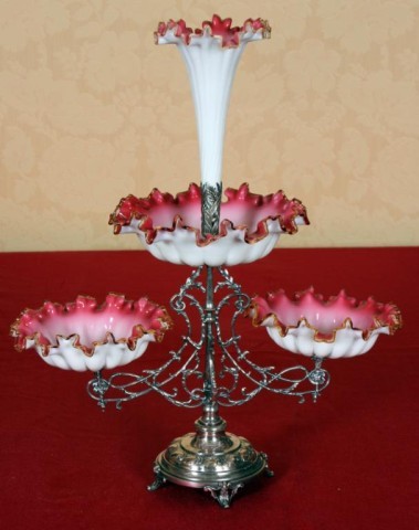 Silver Plated And Victorian Glass Epergne: Silver Plated And Victorian Glass Epergne. A round platform on 4 small feet, has a fancy stem with a center bowl at the top and 2 arms branching out to side bowls. The center bowl is blooming with a t