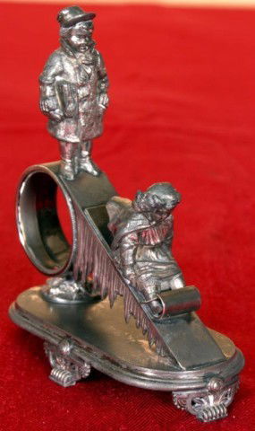 Figural Silver Plate Clock w/ Children Sledding: Figural Silver Plate Clock w/ Children Sledding. Very fine detail, the young girl is on a toboggan going down a hill while the boy waits at the top. Unsigned, missing the timepiece and plating is worn